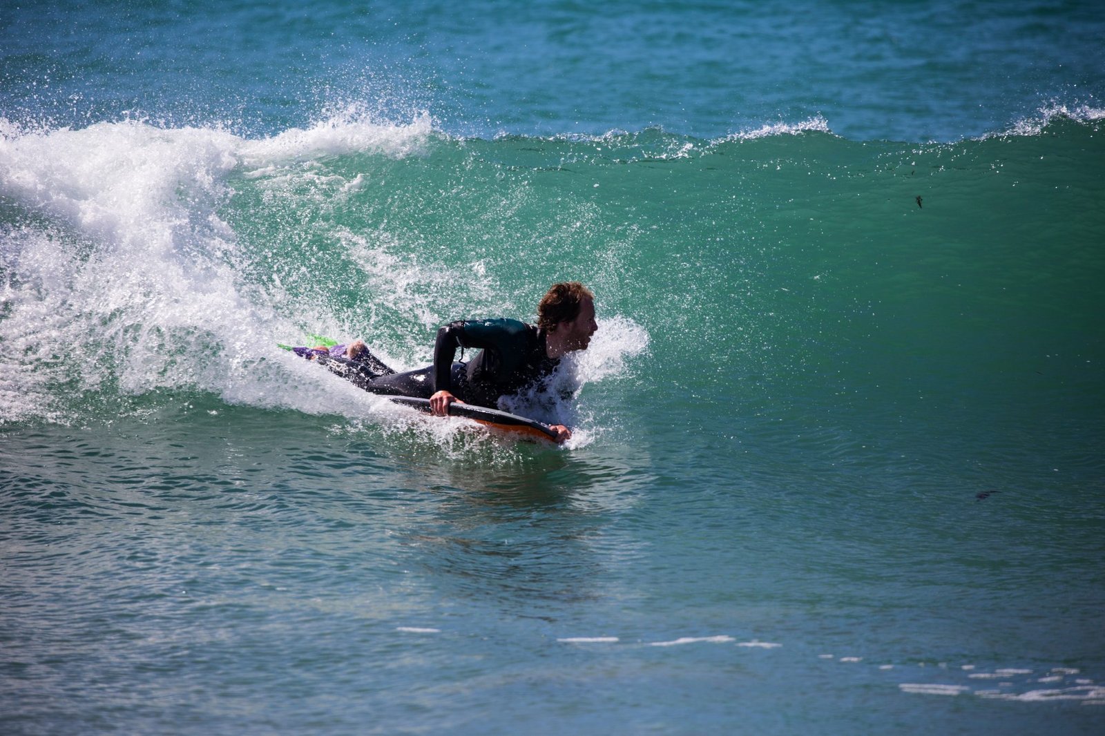 Бодиборд. Бодибординг. Человек на доске в море. Бодибординг (Bodyboarding). Маленькая доска для волн.